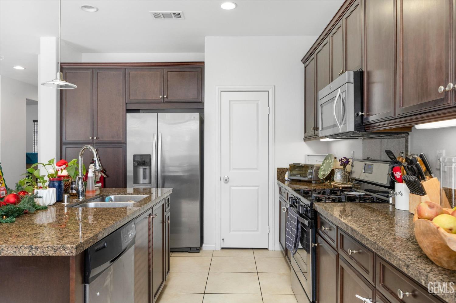 Undisclosed Address Bakersfield, CA 93313 - Photo 14 of 27 a kitchen with stainless steel appliances granite countertop a sink stove and refrigerator