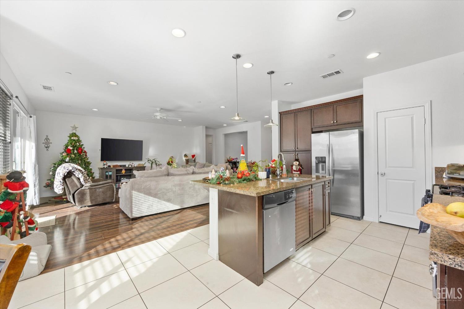 Undisclosed Address Bakersfield, CA 93313 - Photo 15 of 27 a kitchen with stainless steel appliances kitchen island granite countertop a refrigerator and a sink