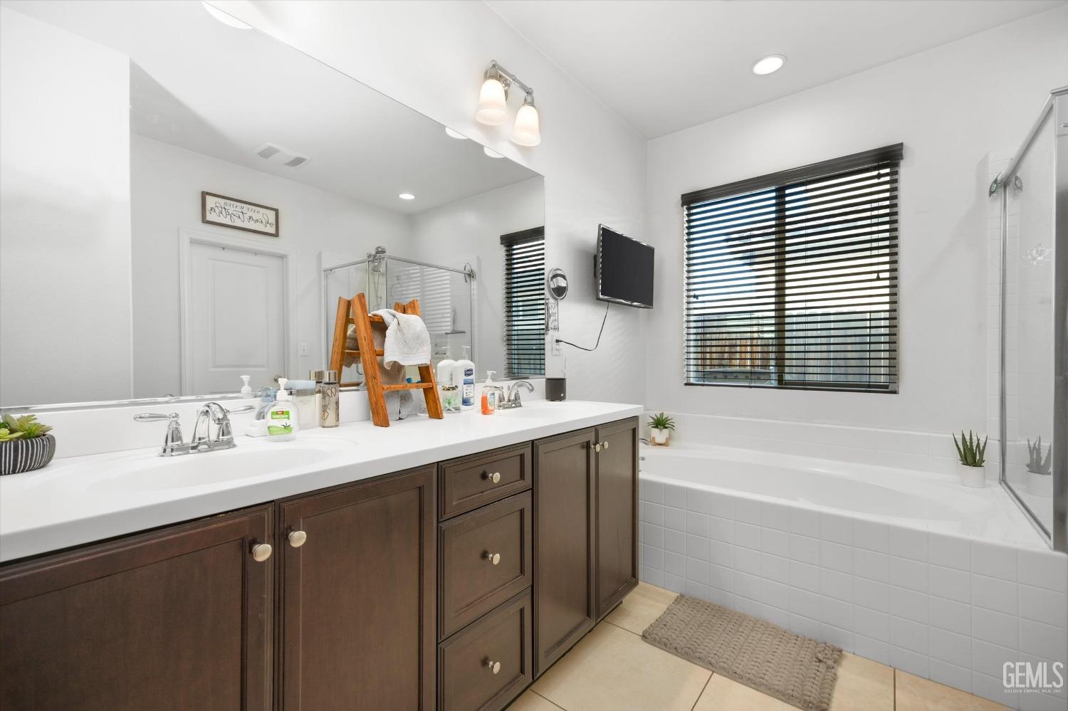 Undisclosed Address Bakersfield, CA 93313 - Photo 18 of 27 a bathroom with a tub sink a mirror a double vanity and window