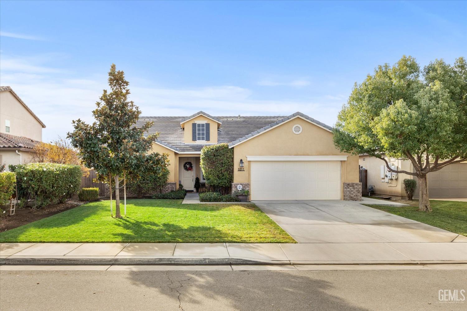 Undisclosed Address Bakersfield, CA 93313 - Photo 2 of 27 a view of a white house with a yard and large trees