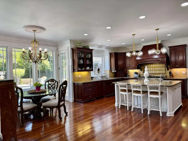a kitchen with a dining table chairs stainless steel appliances and cabinets