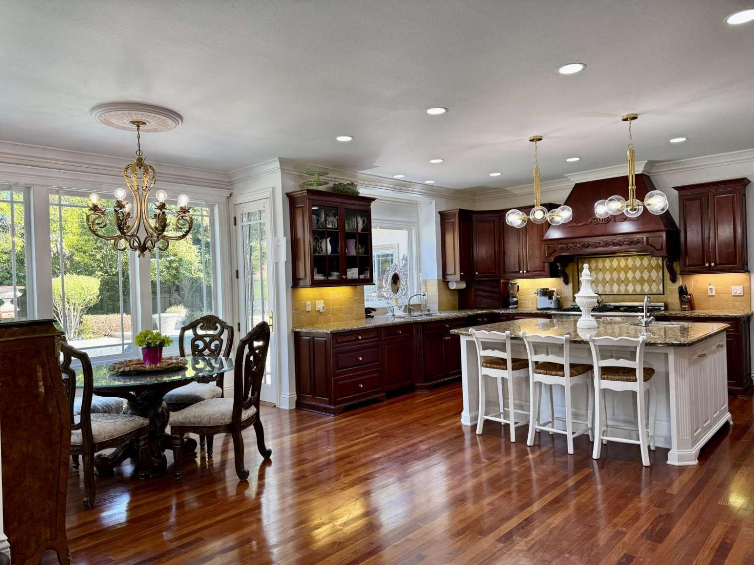5403 Blackhawk Drive Danville, CA 94506 - Photo 11 of 47 a kitchen with stainless steel appliances granite countertop a stove a refrigerator a kitchen island a dining table and chairs with wooden floor