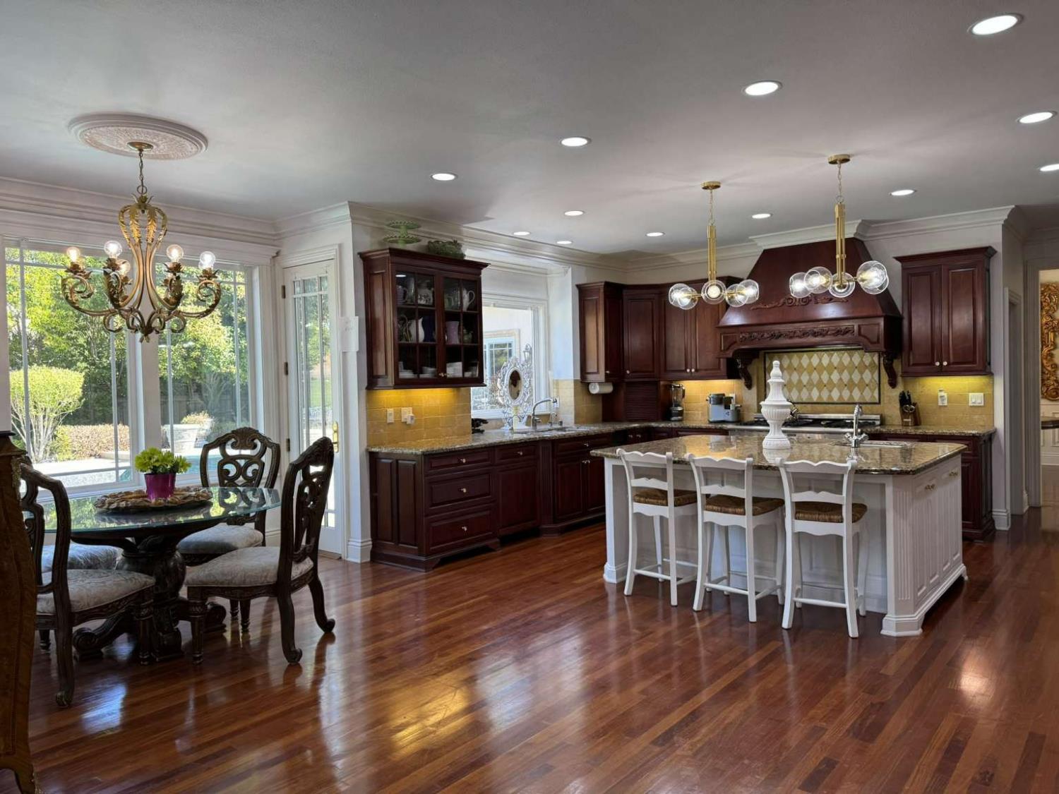 5403 Blackhawk Drive Danville, CA 94506 - Photo 3 of 47 a kitchen with stainless steel appliances granite countertop a stove top oven a sink dishwasher a dining table and chairs with wooden floor
