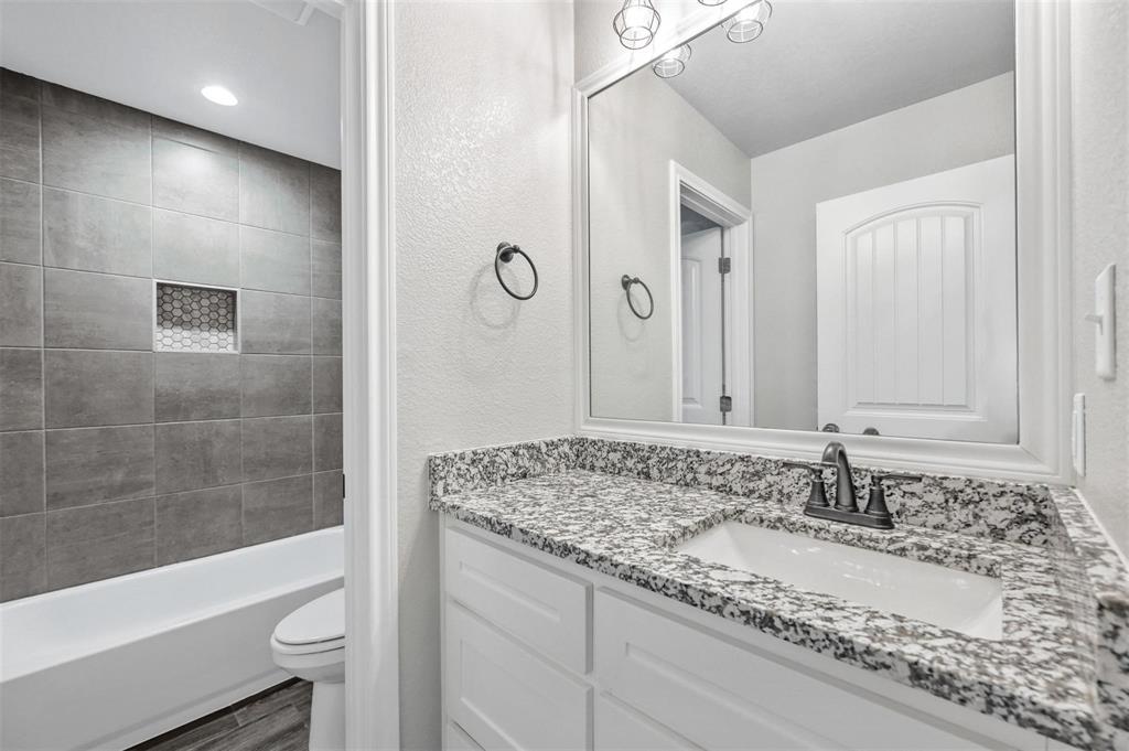 228 St Charles Drive, Unit B Springtown, TX 76082 - Photo 12 of 20 a bathroom with a granite countertop sink and a bathtub