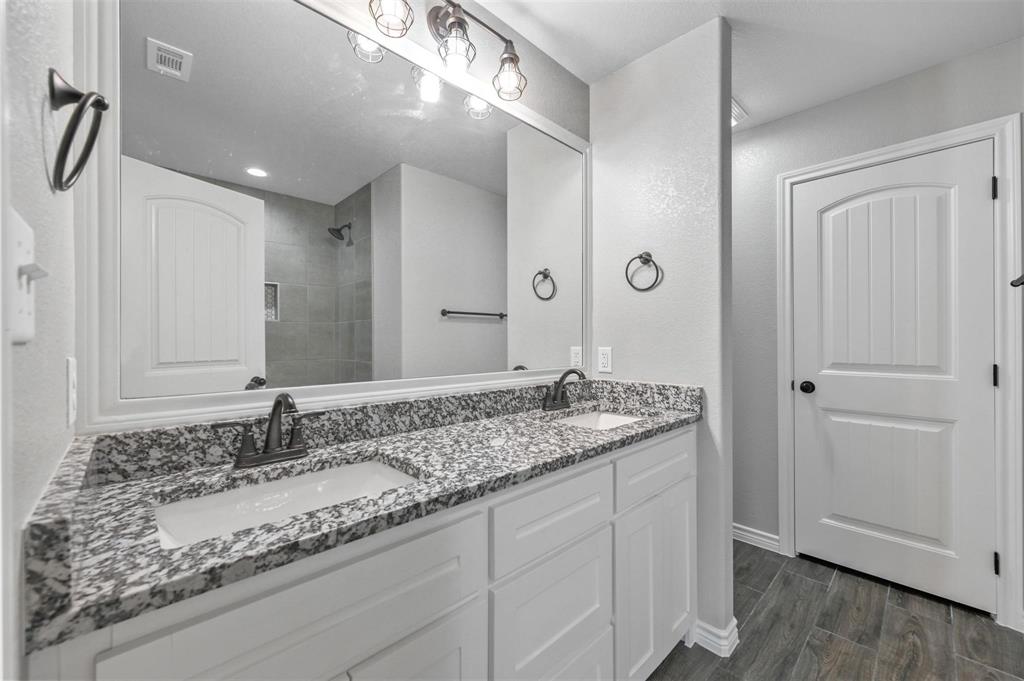 228 St Charles Drive, Unit B Springtown, TX 76082 - Photo 13 of 20 a bathroom with a granite countertop sink and a mirror