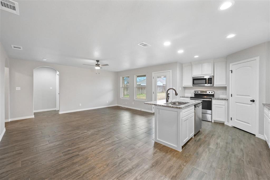 228 St Charles Drive, Unit B Springtown, TX 76082 - Photo 5 of 20 a kitchen with granite countertop a stove top oven sink and cabinets