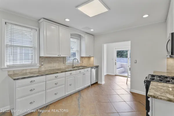 a large kitchen with a stove a sink dishwasher and a refrigerator