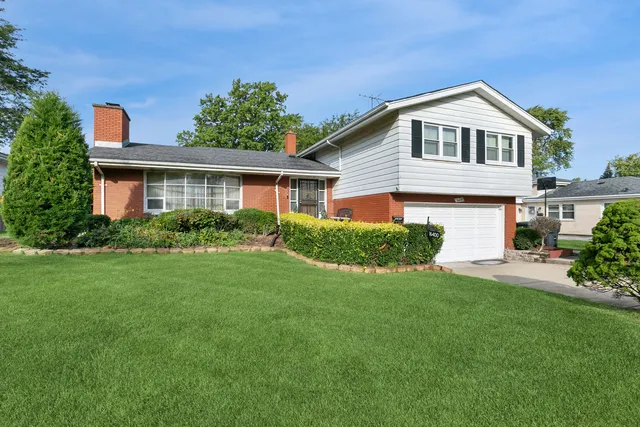 a front view of a house with a yard and potted plants