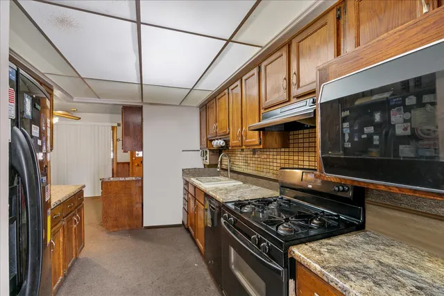 a kitchen with stainless steel appliances granite countertop a stove and a refrigerator