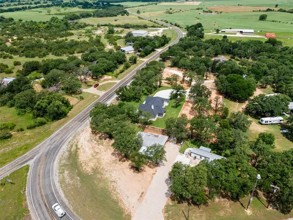 an aerial view of a house with a yard and lake view