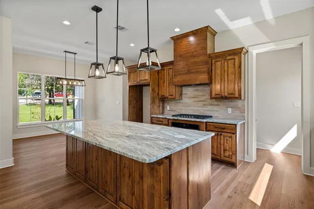 a kitchen with kitchen island a counter top space a sink stainless steel appliances and cabinets