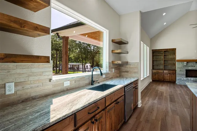 a kitchen with granite countertop a sink and a stove