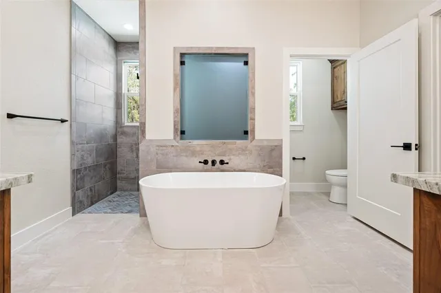 a white bath tub sitting next to a white toilet