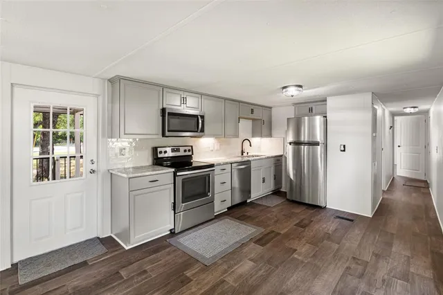 a kitchen with a refrigerator stove top oven and sink