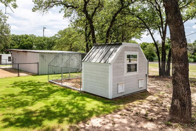a view of a backyard with a large tree and wooden fence