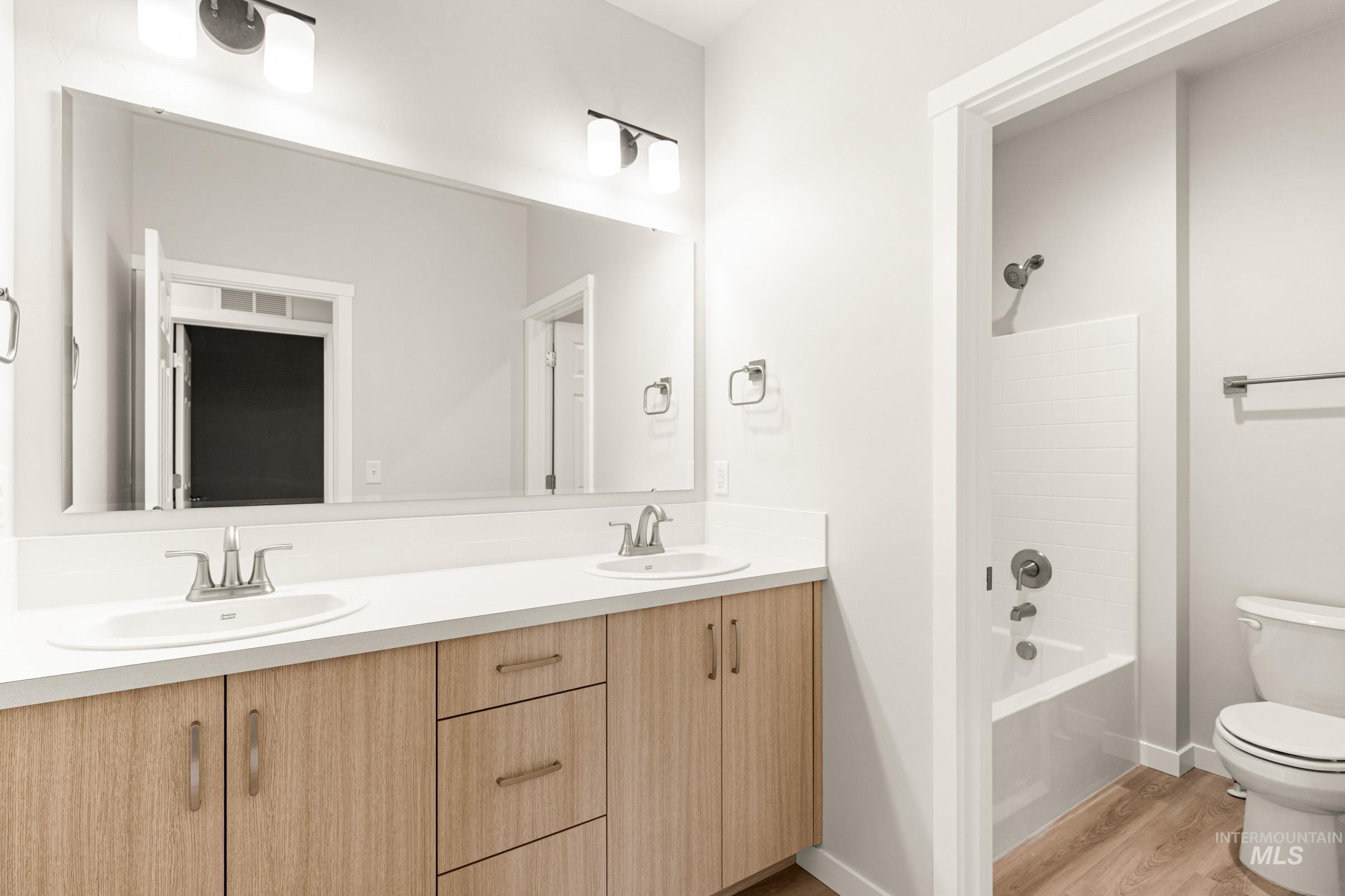 13688 Redway Court Caldwell, ID 83607 - Photo 22 of 26 Bathroom with double vanity, bathing tub / shower combination, and light wood-type flooring