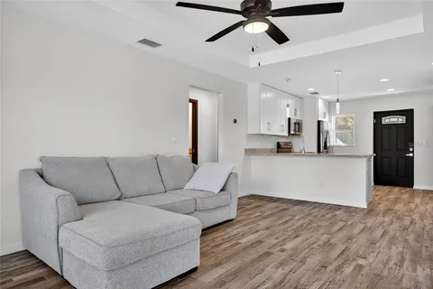 a living room with furniture and kitchen view