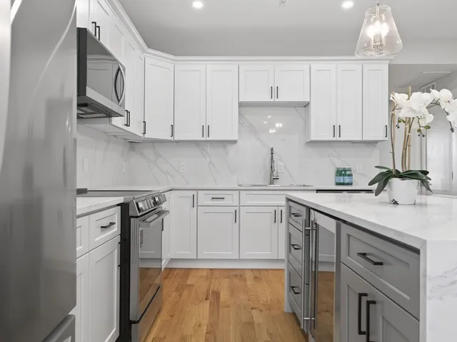 a kitchen with white cabinets and appliances