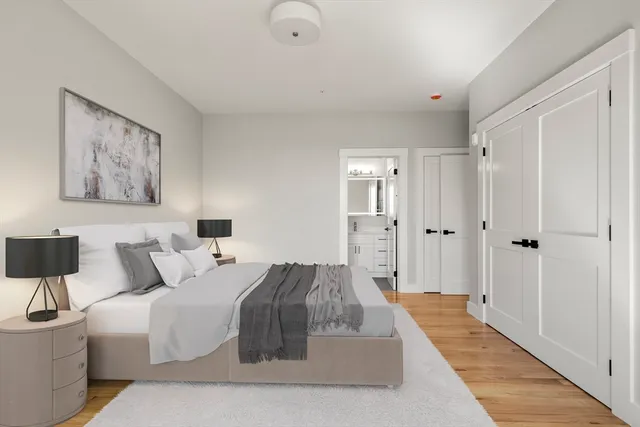 a spacious bedroom with a bed and a painting on the wall