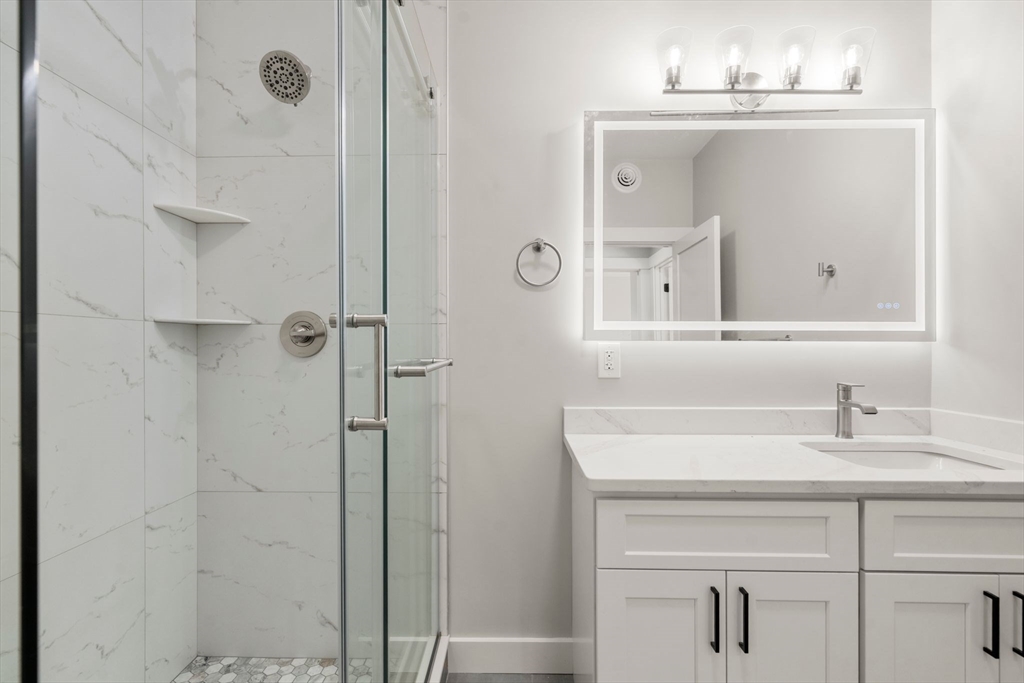 60 Stanley Street, Unit 101 Boston, MA 02125 - Photo 8 of 11 a bathroom with a sink vanity and a mirror