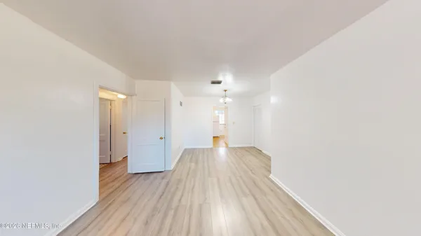 a view of a big room with wooden floor and windows