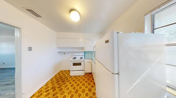 a kitchen with a refrigerator and a stove