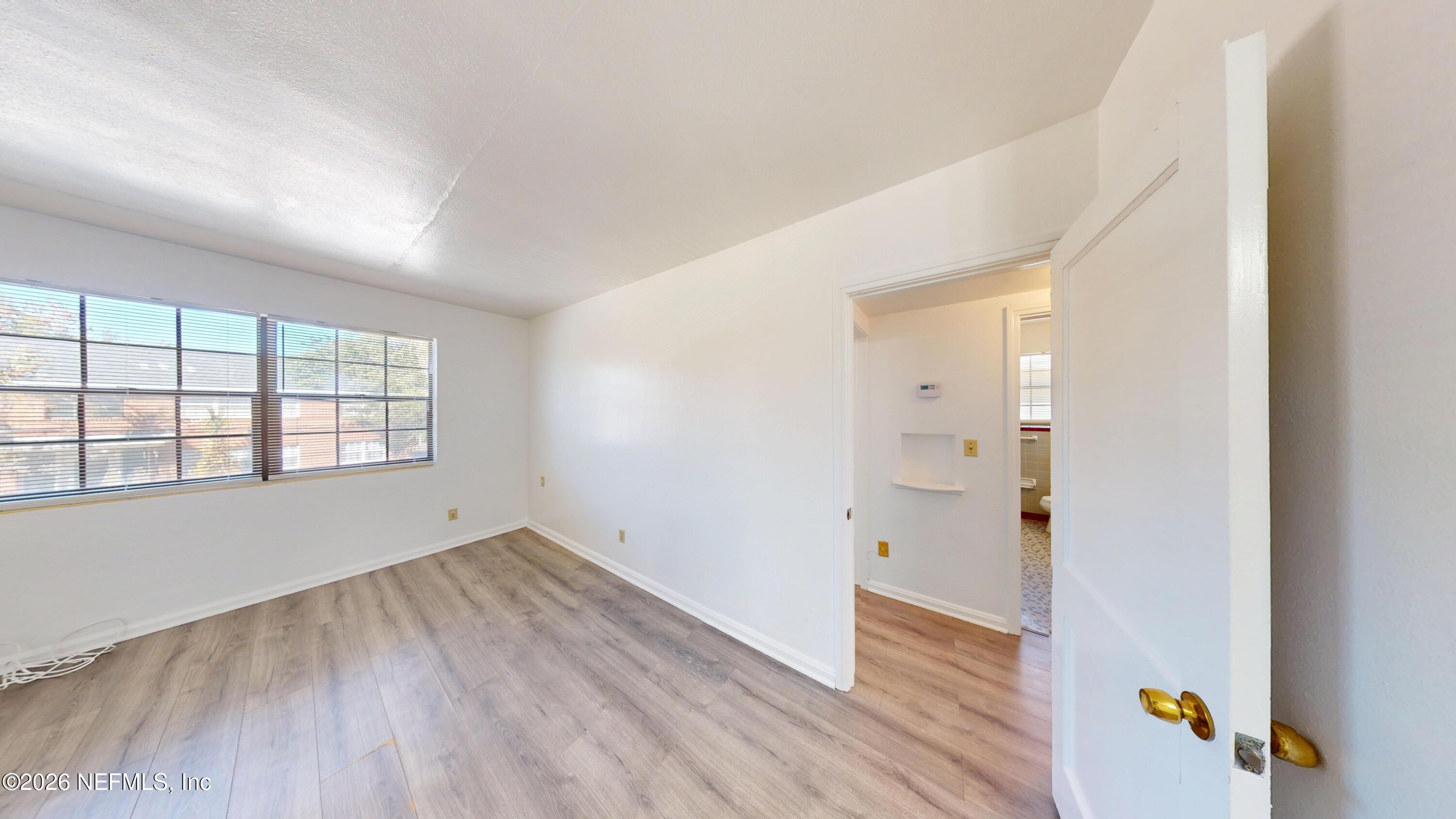3126 Belden Circle, Unit 3 Jacksonville, FL 32207 - Photo 7 of 15 wooden floor in an empty room with a window