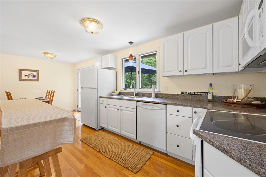 11 Oval Road Chatham, MA 02633 - Photo 7 of 35 a kitchen with granite countertop a sink stainless steel appliances white cabinets and a window