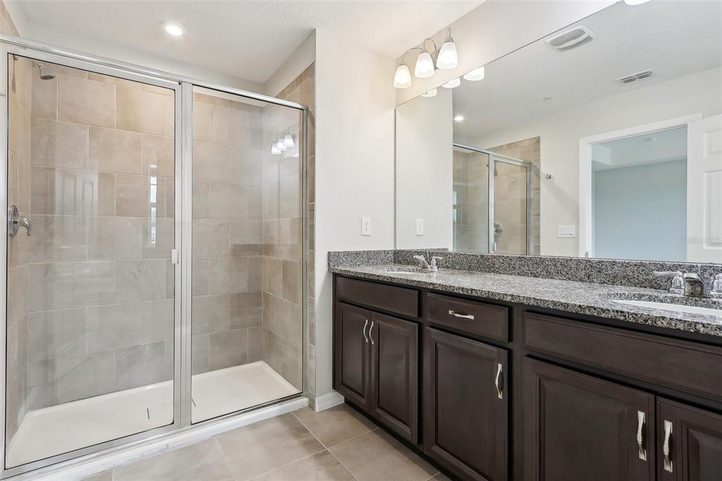 9457 Randal Park Boulevard Orlando, FL 32832 - Photo 34 of 52 a bathroom with a granite countertop shower sink and mirror