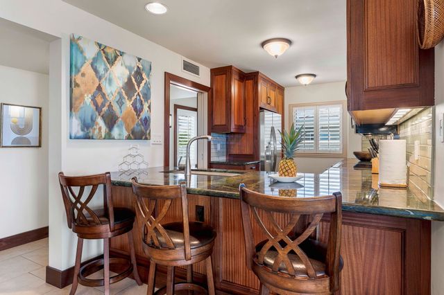 a kitchen with stainless steel appliances granite countertop a stove microwave and cabinets