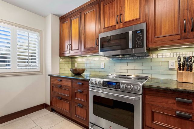 a kitchen with stainless steel appliances granite countertop a refrigerator and a sink