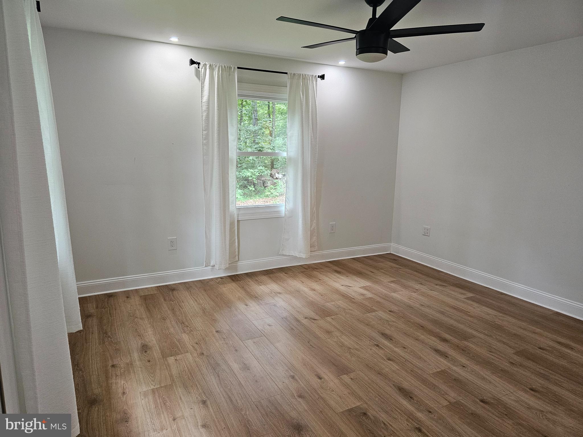 133 Meadows Road Fredericksburg, VA 22406 - Photo 21 of 55 an empty room with wooden floor fan and windows