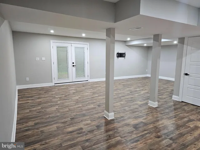 an empty room with wooden floor and natural light