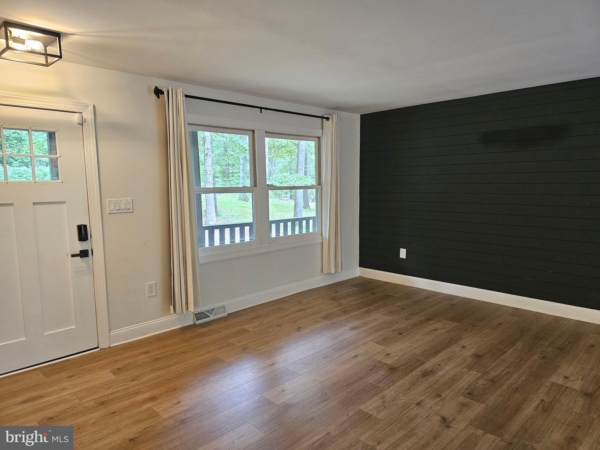 133 Meadows Road Fredericksburg, VA 22406 - Photo 5 of 55 a view of an empty room with wooden floor and a window