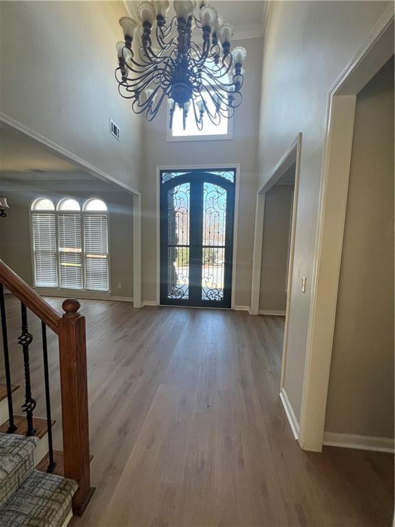 5455 Woodrun Lane Alpharetta, GA 30005 - Photo 12 of 71 a view of a hallway with wooden floor and chandelier