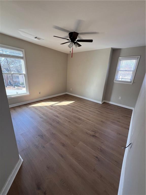 5455 Woodrun Lane Alpharetta, GA 30005 - Photo 50 of 71 an empty room with wooden floor fan and windows