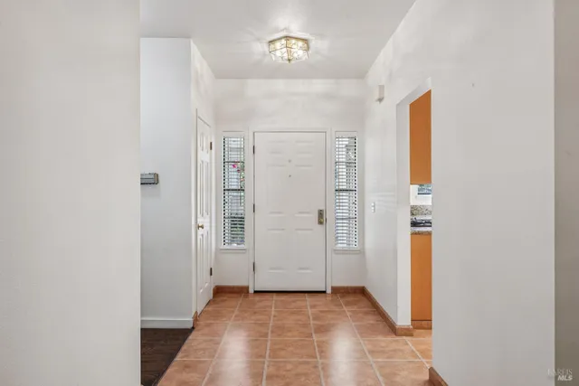 a backyard of a house with table and chairs under an umbrella