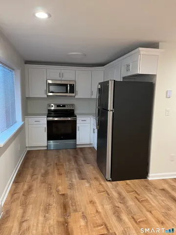 a kitchen with granite countertop a refrigerator and a stove top oven