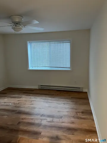 a view of a room with an empty space and wooden floor