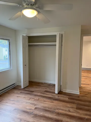 an empty room with wooden floor cabinet and door