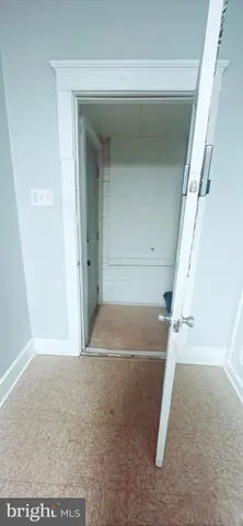 a view of an empty room and kitchen