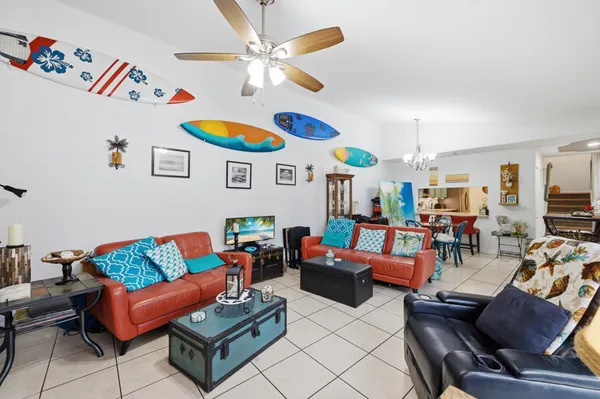a living room with furniture kitchen and a chandelier