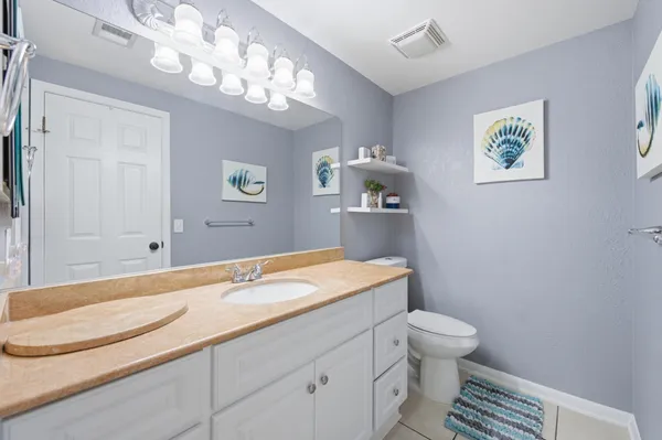 a spacious bathroom with a granite countertop toilet sink and mirror
