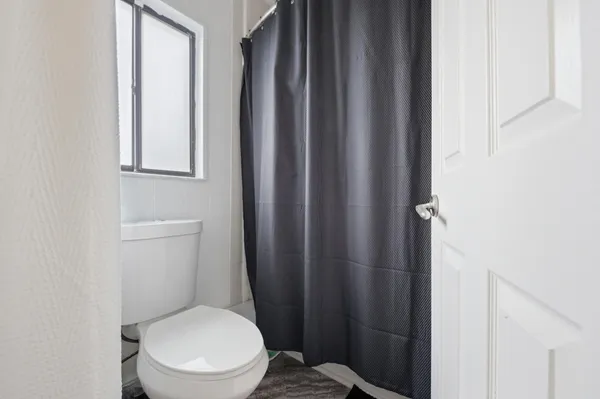 a white toilet sitting next to a window