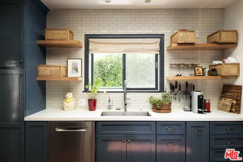 a kitchen with stainless steel appliances a sink and a large window