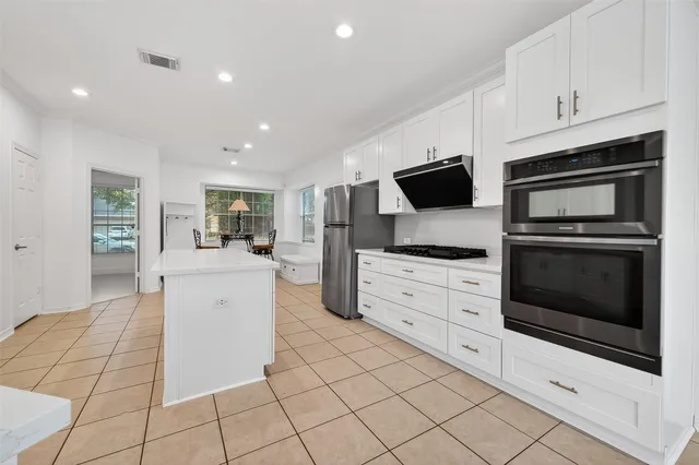 a kitchen with white cabinets and appliances