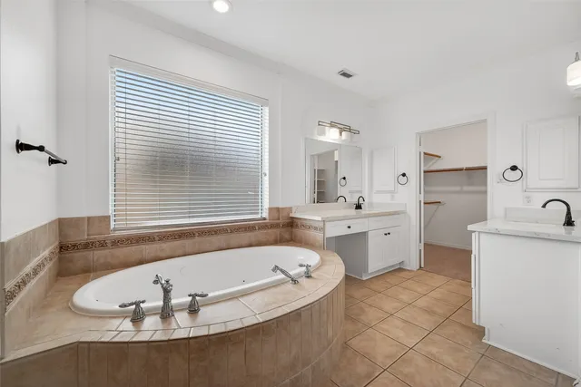 a bathroom with a granite countertop sink mirror bathtub and toilet