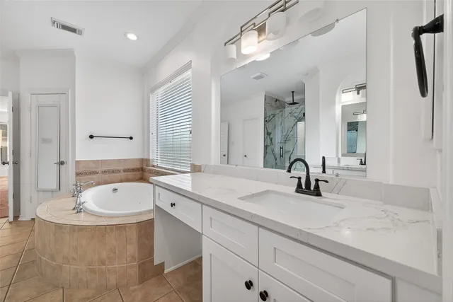 a bathroom with a double vanity sink a mirror and bathtub