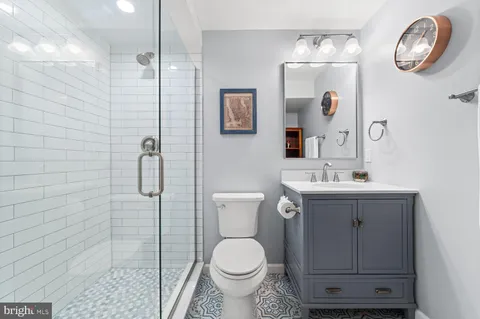 a bathroom with a toilet sink vanity and mirror