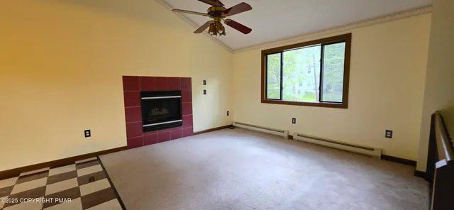 a view of an empty room with a fireplace and a window